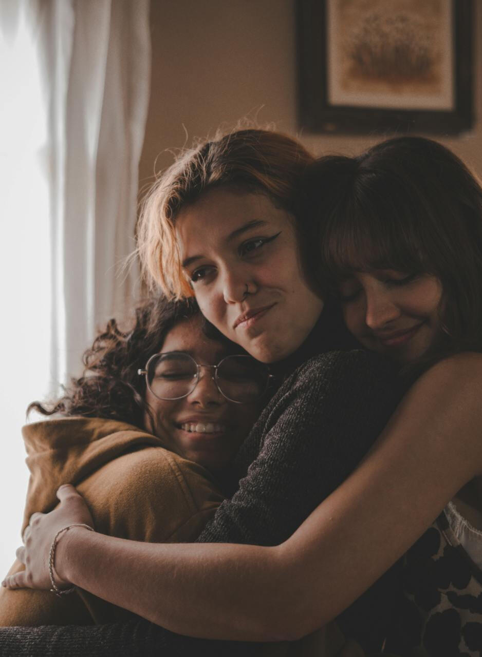 three girls all hugging each other